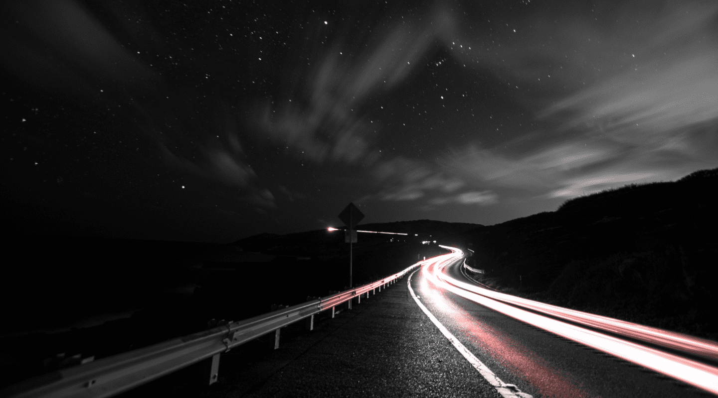 Um caminho curvo de uma estrada vazia a noite